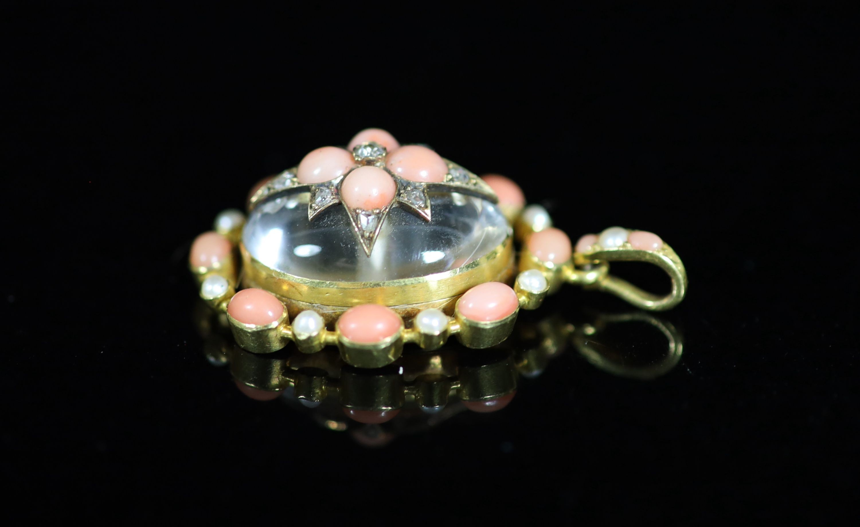 A Victorian gold, coral, seed pearl and diamond set rock crystal oval pendant
